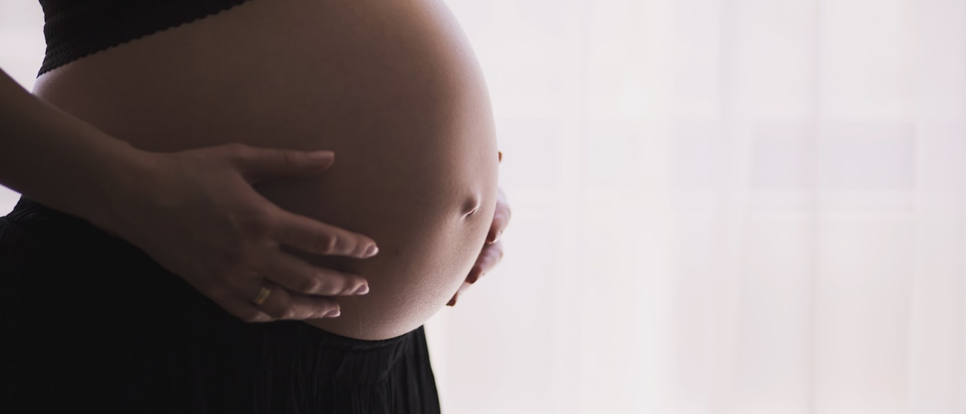 Woman gently holding her pregnant belly — due date calculation
