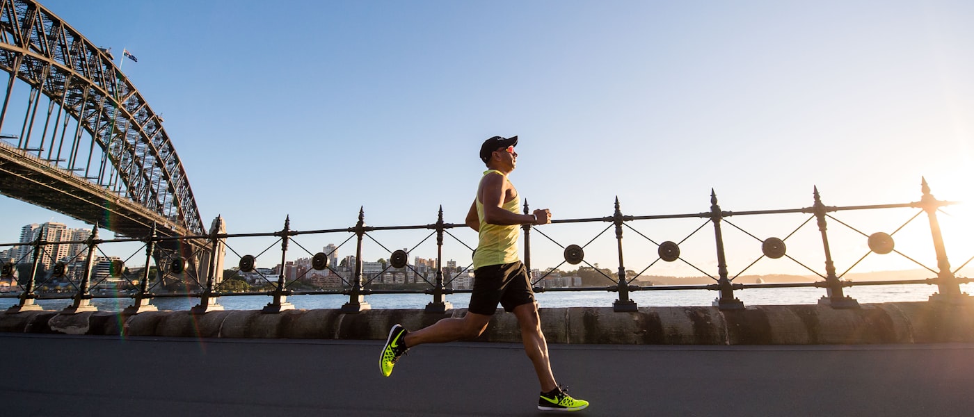 Woman running along the ocean at sunrise for cardio and BMR training